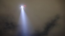 Helicopter shining light from the sky.