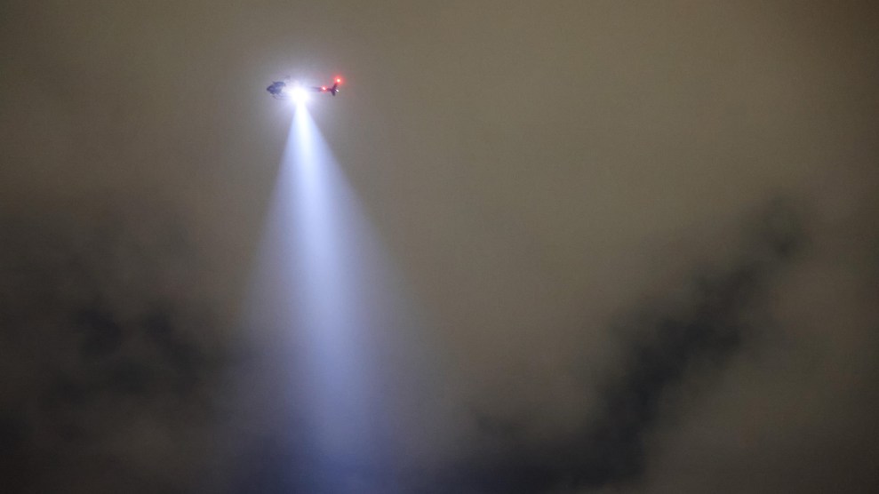 Helicopter shining light from the sky.