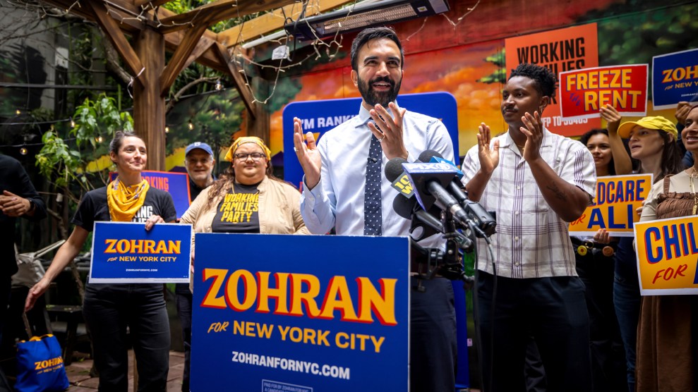 Zorhan Mamdani speaks to a crowd of supporters, who hold campaign signs.