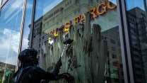 A protester smears a thick, oil-like mixture on a Wells Fargo bank's window