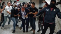 Brad Lander in a hallway surrounded by officers, most in plainclothes, grabbing his arms and leading him away. At least three of the officers are wearing masks.