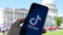 In this photo illustration, a phone displaying the TikTok logo is held up in front of the U.S. Capitol Building.