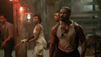 Michael B. Jordan wearing a white tank top with three Black actors behind him