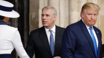 Melania Trump and her large white hat can be seen from behind as she shakes hands with England's Prince Andrew. President Trump is also in the photo, displaying an unhappy facial expression.