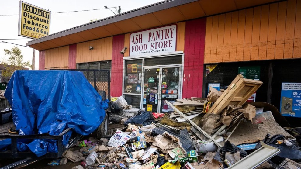 Piles of layered debris in front of an orange and red building with a sign that says, "Ash Pantry Food Store."