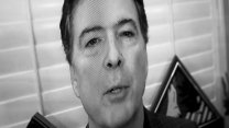 A black-and-white image of TV screen showing a man talking.