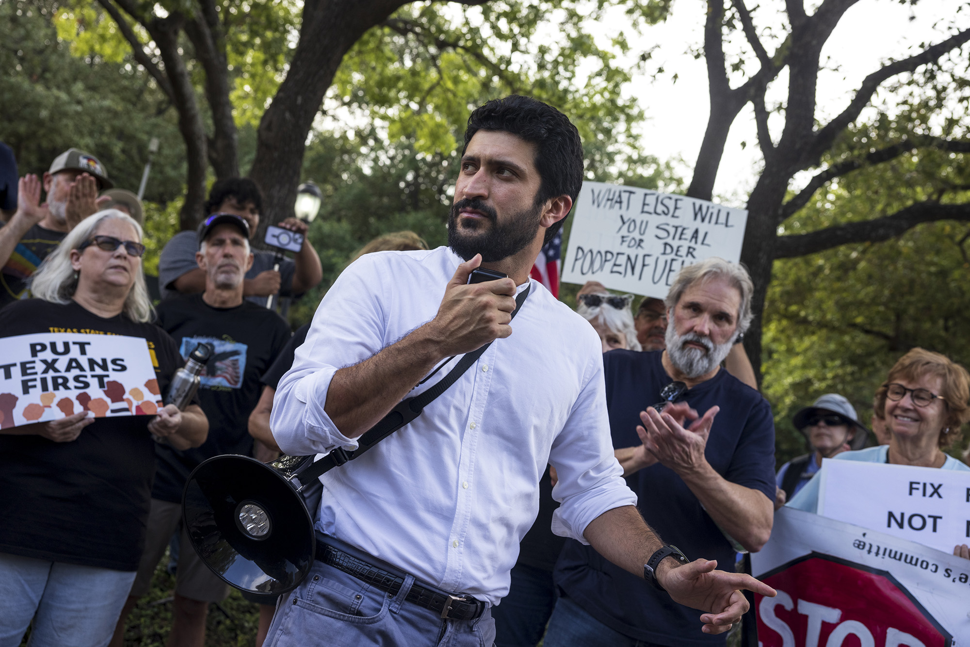 Greg Casar holding a megaphone with a crowd behind him.