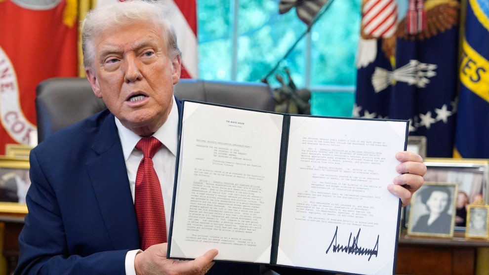 President Trump holds up a memorandum on countering domestic terrorism while in the Oval Office