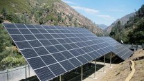An array of solar panels next to a mountain side