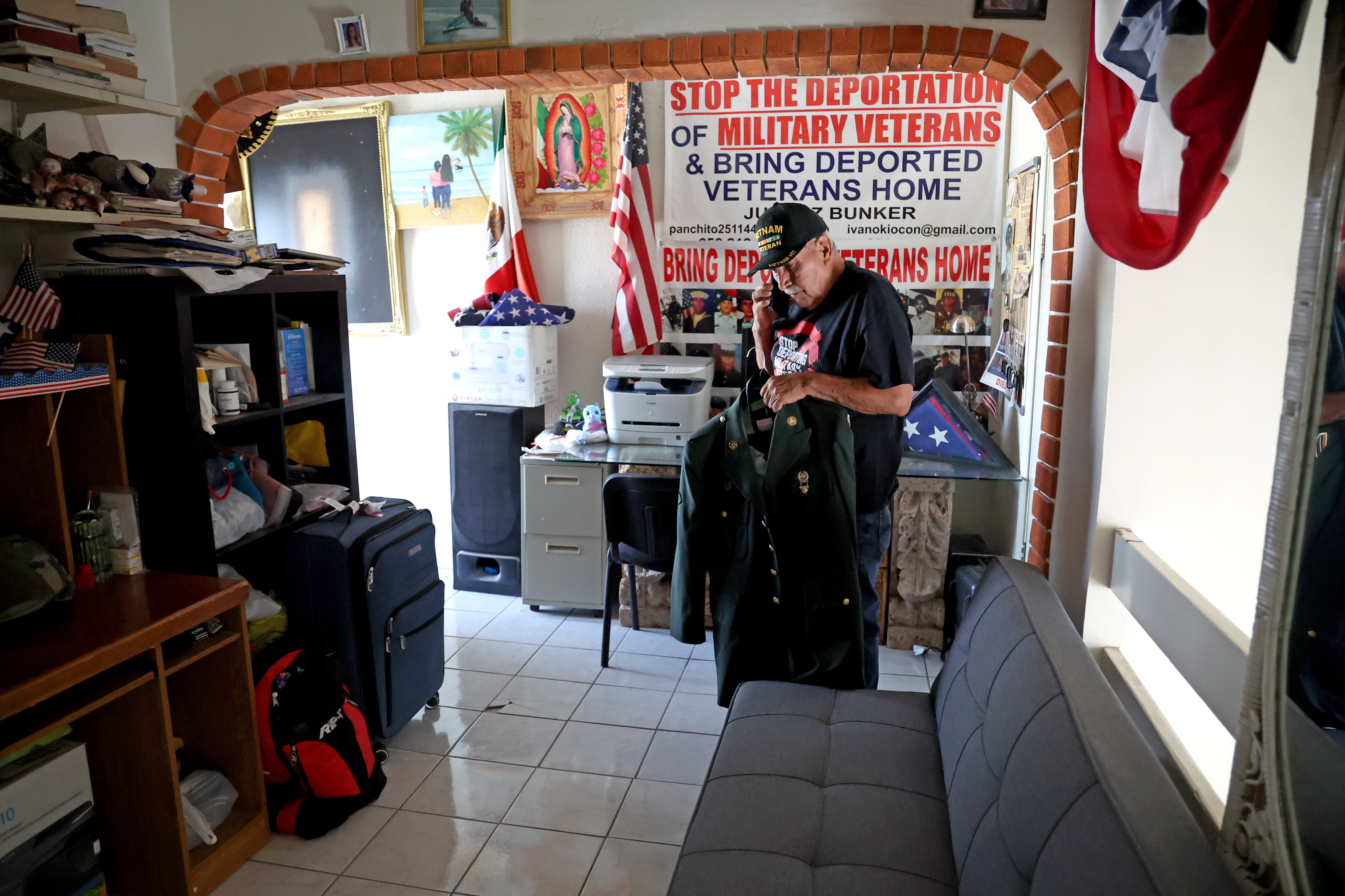 Veteran Jose Francisco Lopez holds his military uniform.