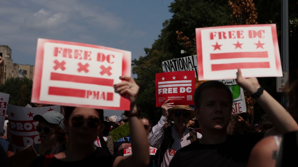 Two people hold signs with the DC flag reading "FREE DC"