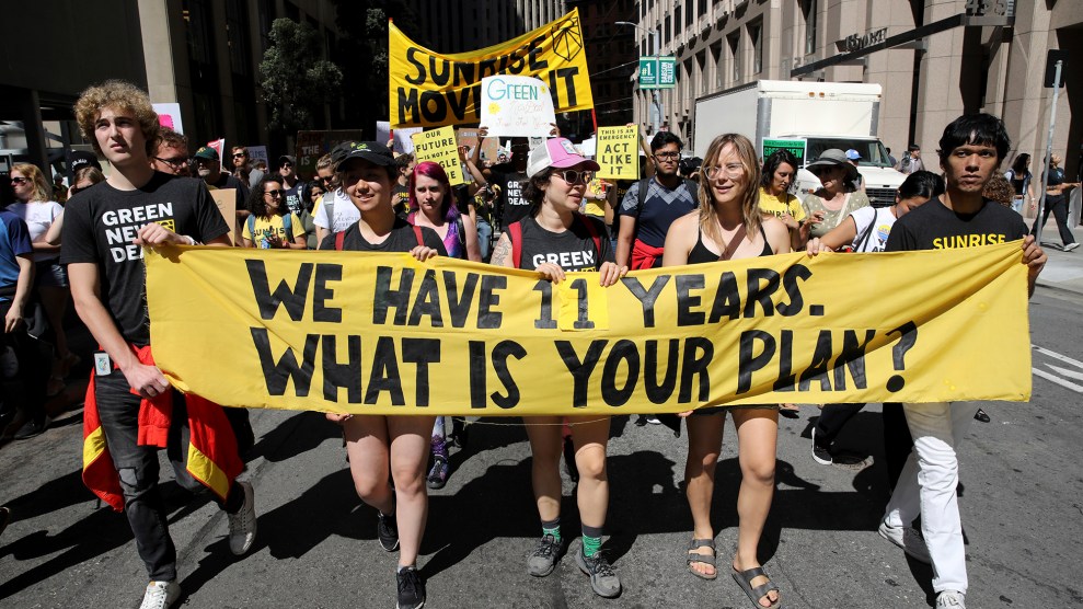 Five people hold a banner that says "We have 11 years, what is your plan?"