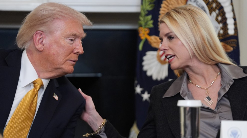 Pam Bondi leans toward Trump with her hand on his shoulder. Both are seated.