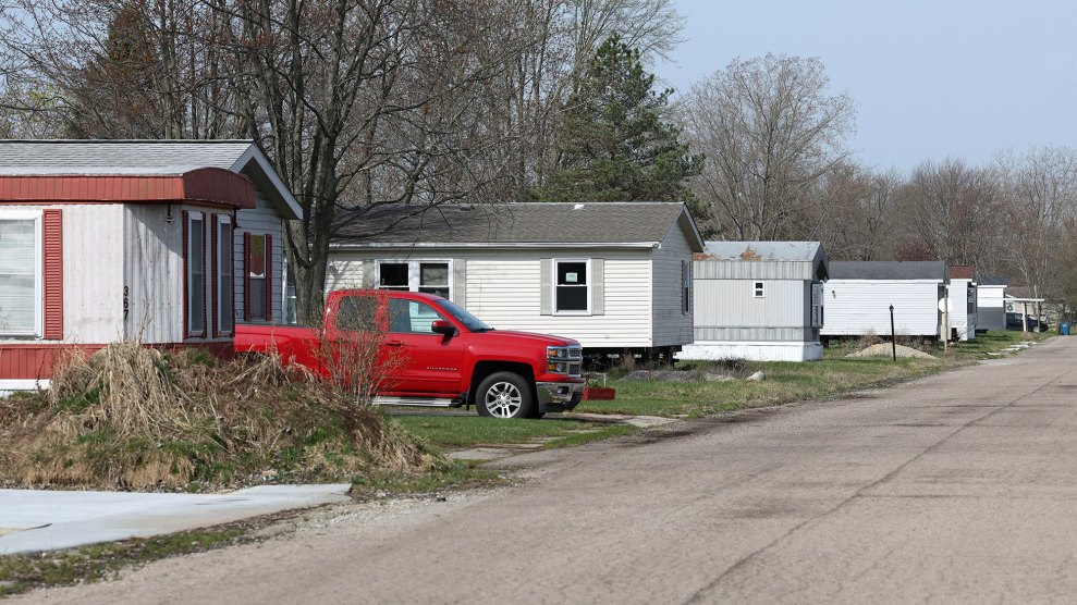 A street with a row of mobile homes, one with a red pickup in front.