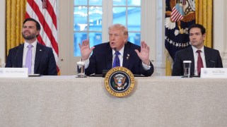 From left to right: JD Vance, Donald Trump, and Marco Rubio sit at a table. They are all wearing suits. In front of Trump is a sign that says Seal of the President of the United States."