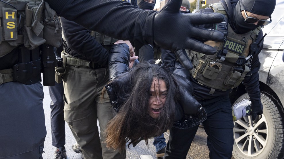 Federal agents carry a crying woman away.
