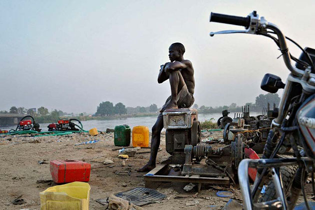 At the end of the day Martin Lou Lawrence, a mechanic who works on water pumps near the Nile River, looks at the last trucks filling up. Juba city, South Sudan’s capital, has no running water system. Near Knoyo Konyo Market, one filling station with 24 pumps fills up 200 trucks a day with non-treated Nile River water to supply the city.