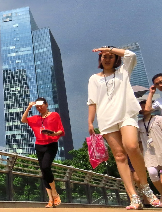 Pedestrians in Shanghai cover themselves from the scorching sun on August 6, 2013.